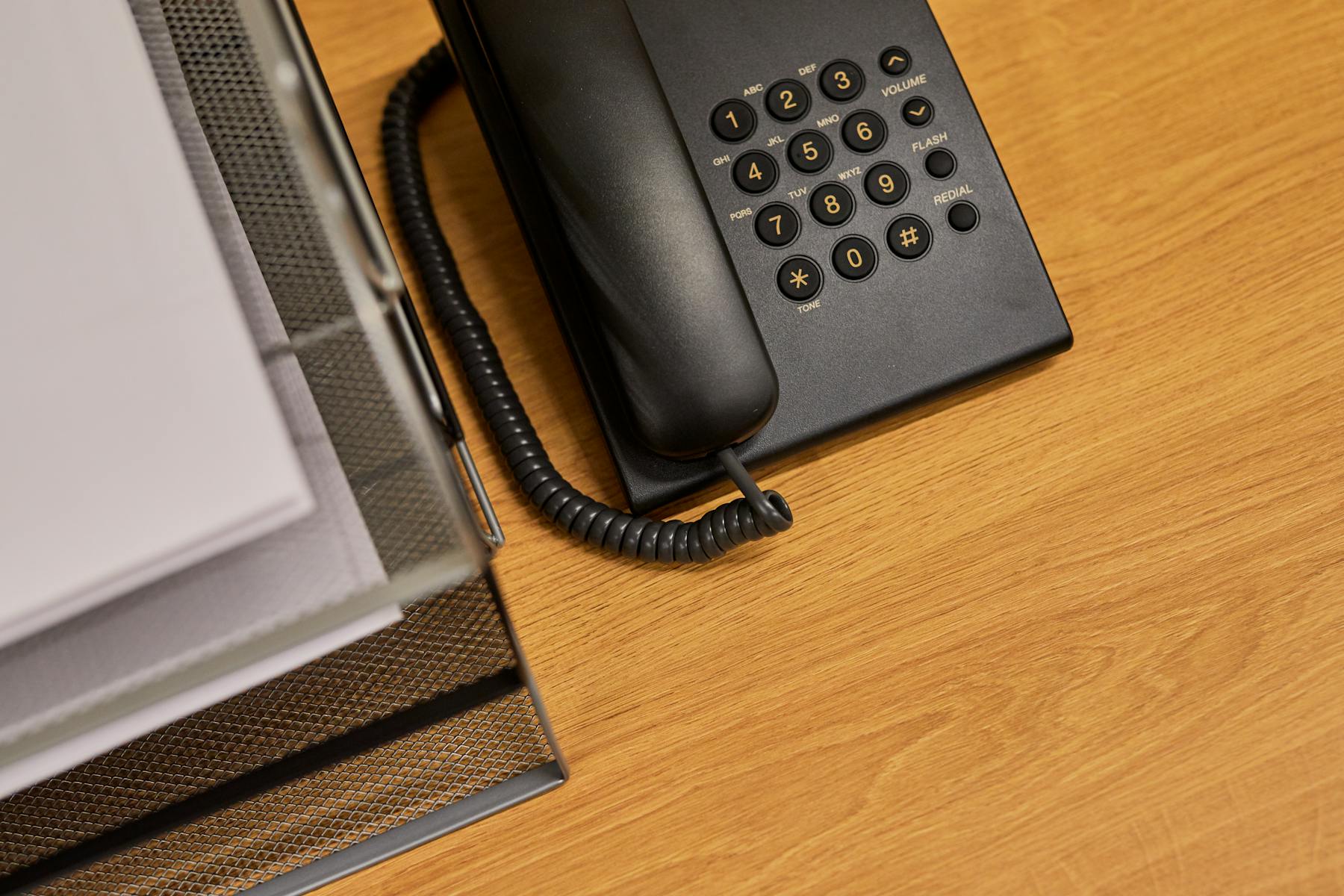 Office phone and organized documents on a professional desk